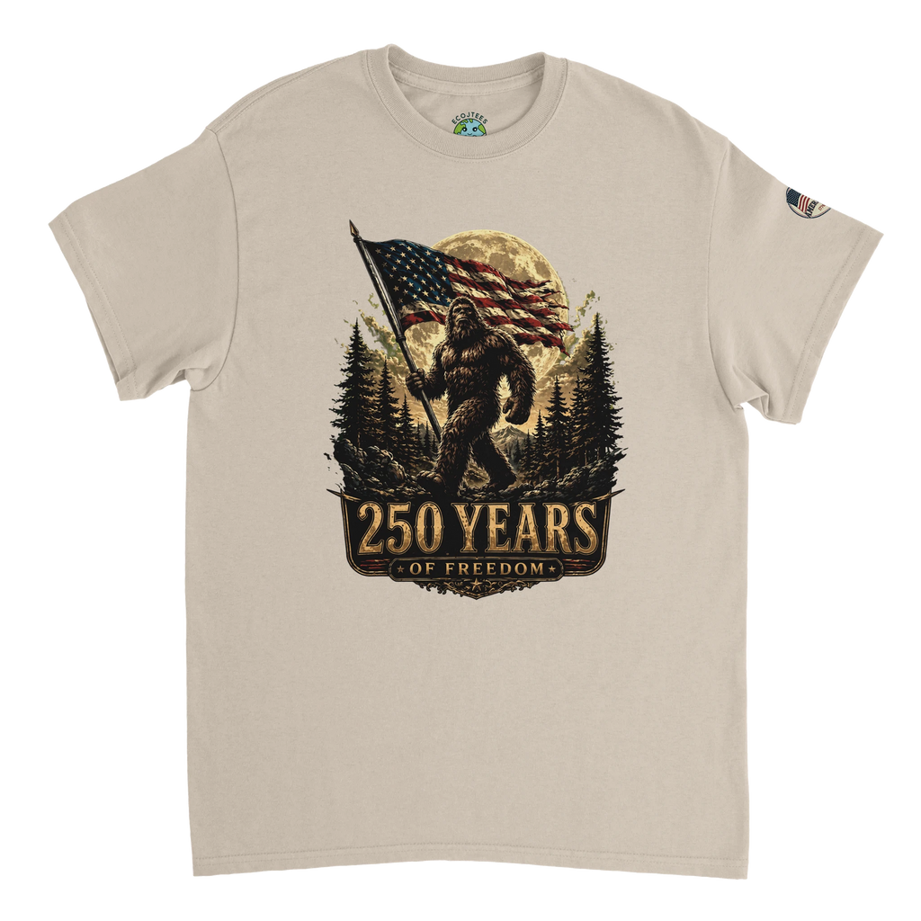Beige t-shirt with a graphic of Bigfoot holding an American flag and '250 Years of Freedom' text on a white background.