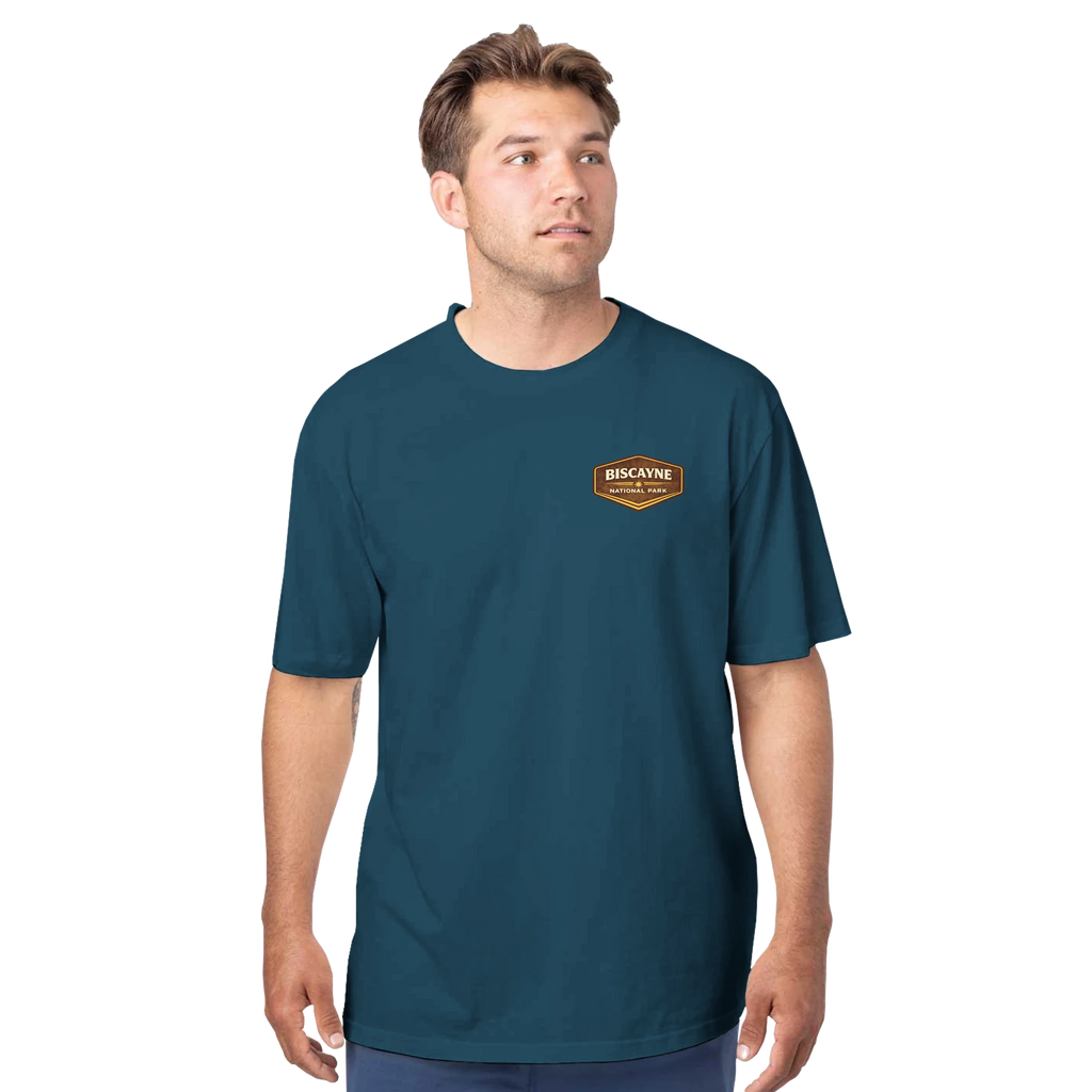 Man wearing a teal t-shirt with a logo on a white background