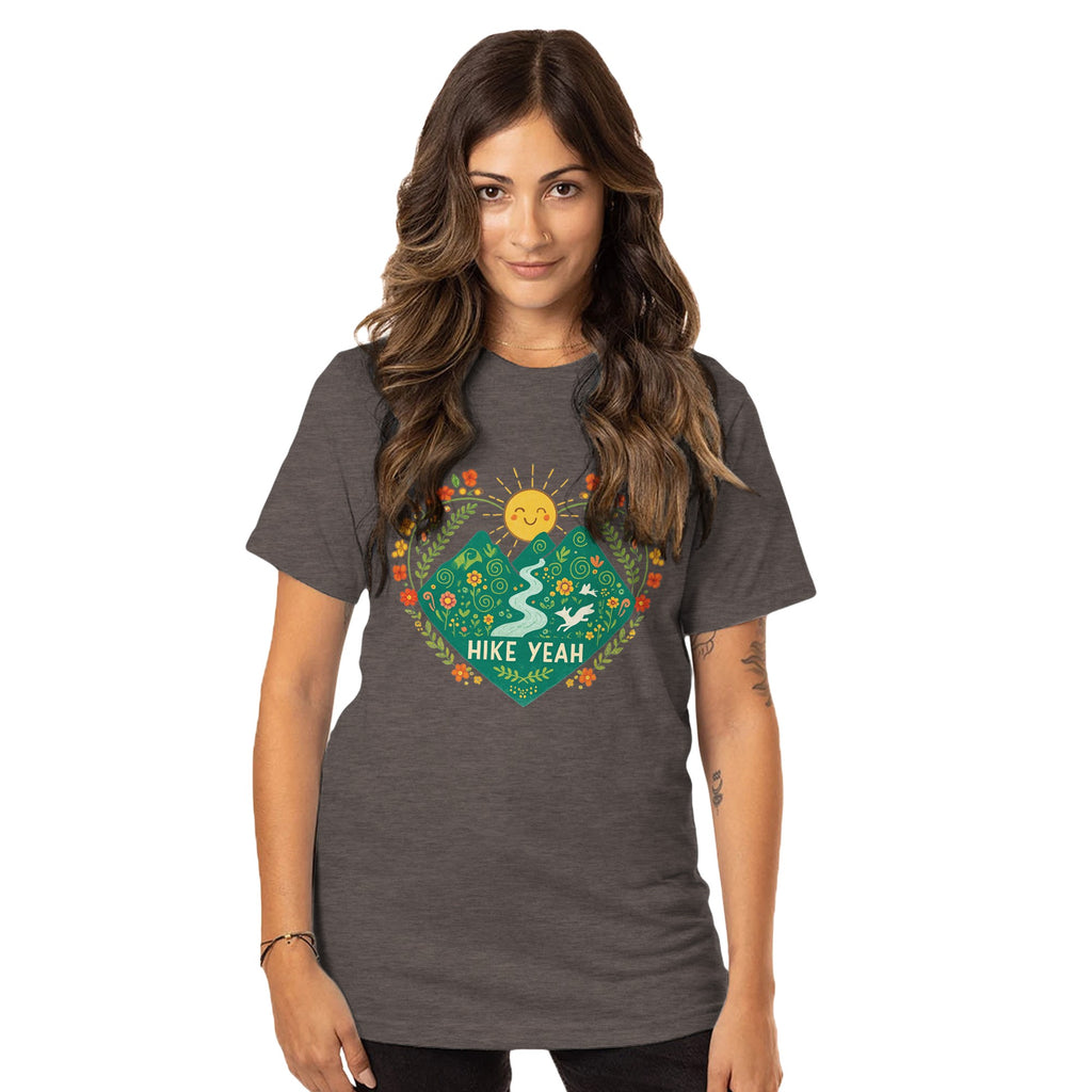 Woman wearing a brown t-shirt with a nature-themed graphic and 'Hike Yeah' text on a white background