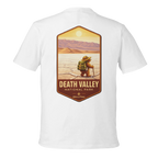 White t-shirt with a graphic of a person in a hat and backpack in Death Valley National Park on a white background