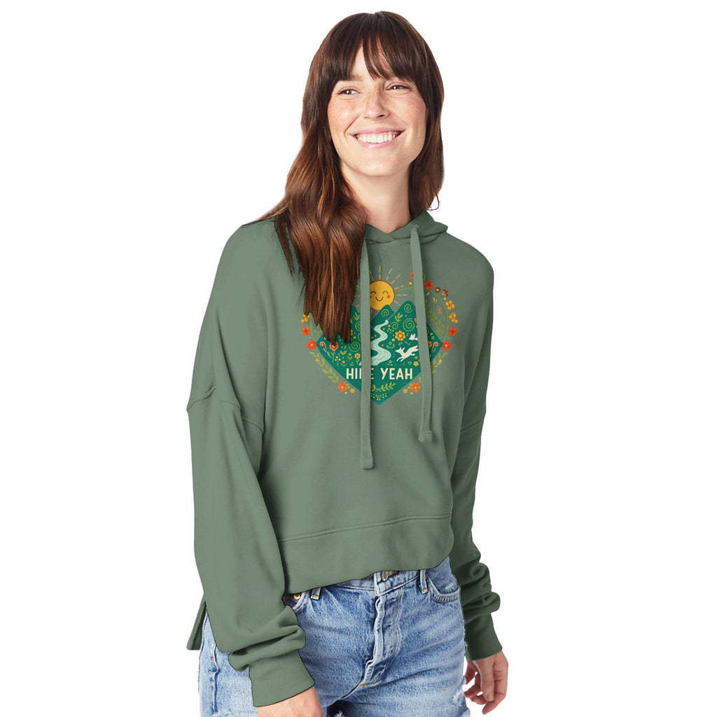 Woman wearing a green hoodie with a colorful graphic design on a white background
