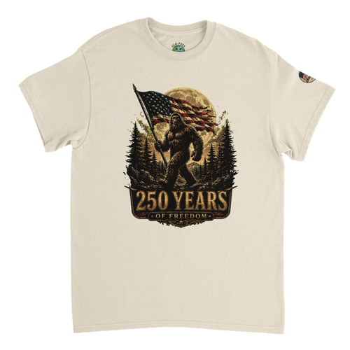 Sand t-shirt with a Bigfoot graphic holding an American flag and '250 Years of Freedom' text on a white background.